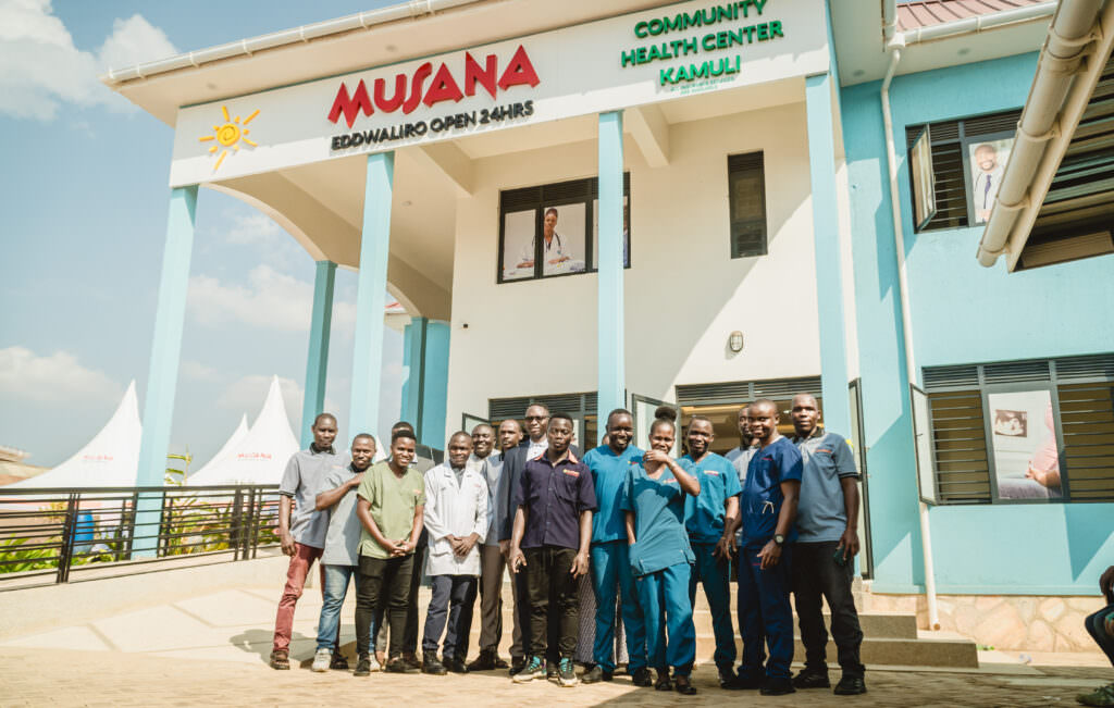 Doctors and nurses standing together outside Musana Community Health Center in Kamuli, Uganda, highlighting Musana’s sustainable healthcare model