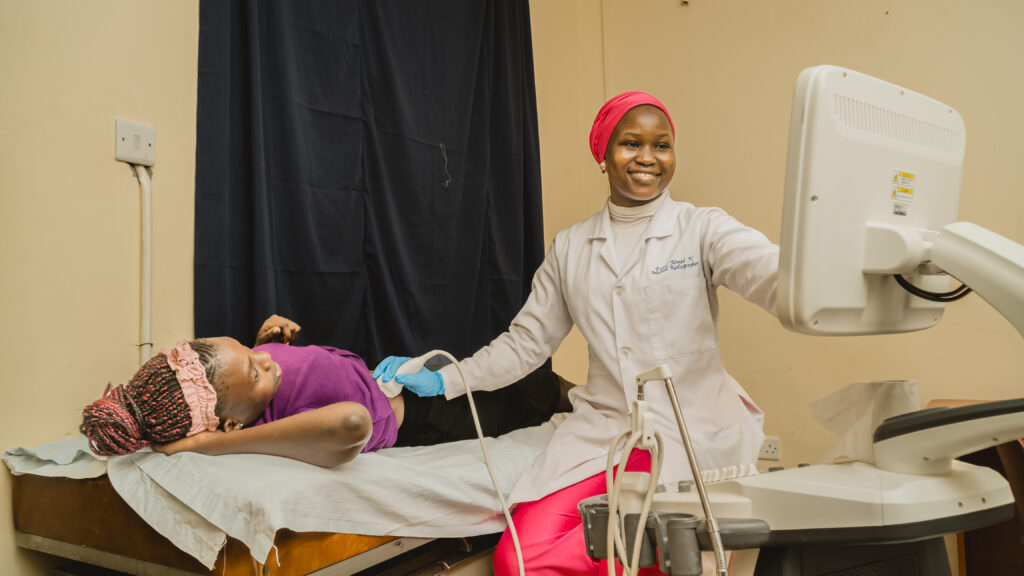 Female healthcare worker performing an ultrasound scan on a patient at Musana Community Health Center in Uganda